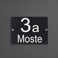 Personalizirana hišna tablica z hišno številko in imenom ulice na sodobni hiši.